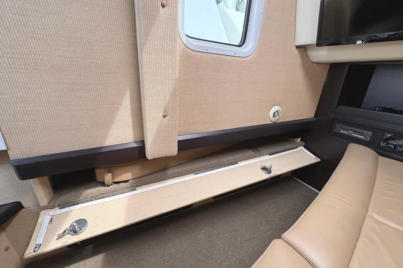 Slide: The Image of Interior of a 2018 Cobalt R35 boat with beige upholstery and storage compartment. - 42