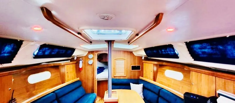 Slide: The Image of Interior of a 2002 Hunter 356 yacht with blue seating. - 10