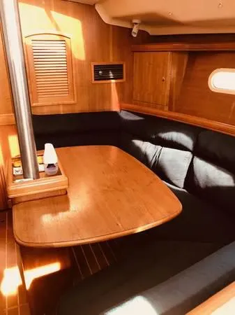 Slide: The Image of Interior of a 2002 Hunter 356 yacht with wooden table and seating area. - 18