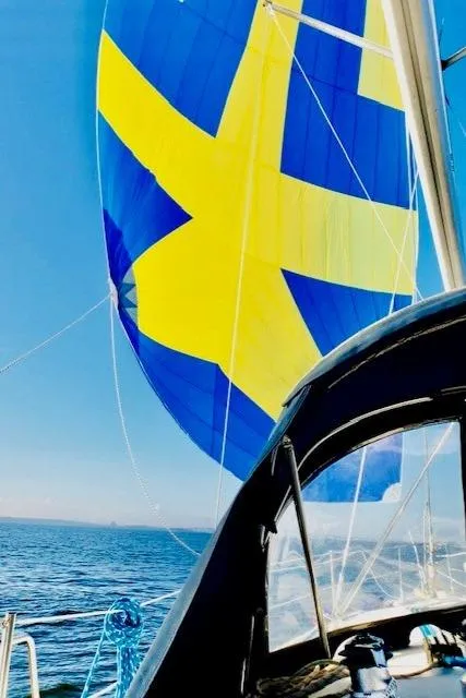 Slide: The Image of 2002 Hunter 356 sailboat with blue and yellow sail on open sea. - 2