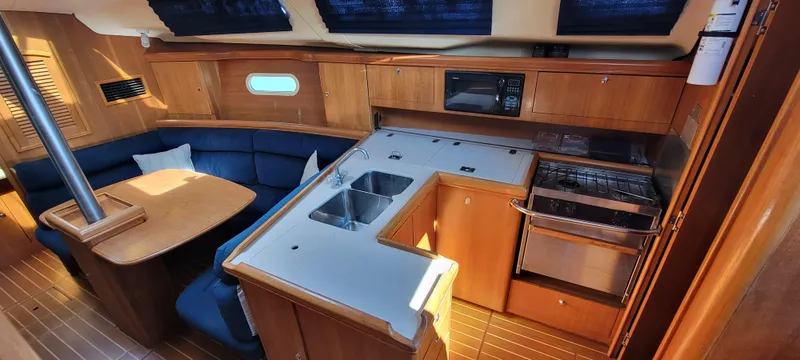Slide: The Image of Interior of a 2002 Hunter 356 yacht with kitchen and seating area. - 22