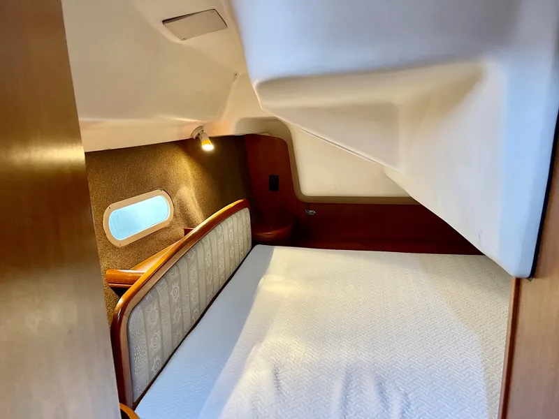 Slide: The Image of Interior of a 2002 Hunter 356 yacht featuring a cozy sleeping area. - 25