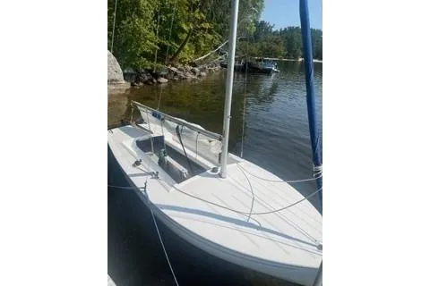 Slide: The Image of 2016 Flying Scot 19 sailboat docked by a serene lakeside. - 4