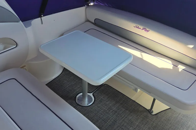 Slide: The Image of Interior seating area of 2006 Sea Ray 300 Sundancer with table and cushioned benches. - 10