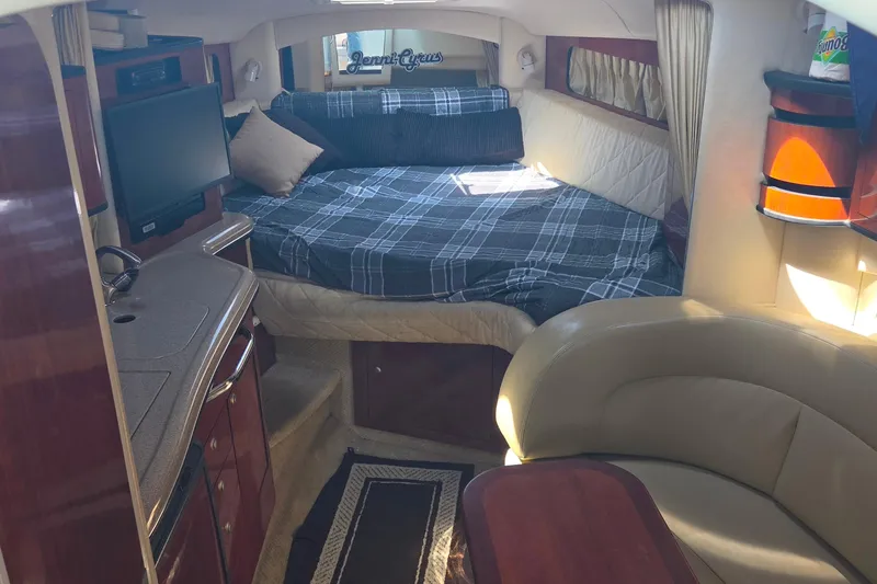 Slide: The Image of Interior of 2006 Sea Ray 300 Sundancer with cozy bed, TV, and seating area. - 12