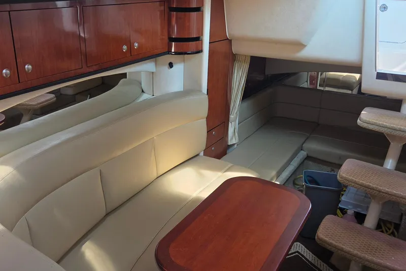 Slide: The Image of Interior of 2006 Sea Ray 300 Sundancer with beige seating and wooden cabinetry. - 13