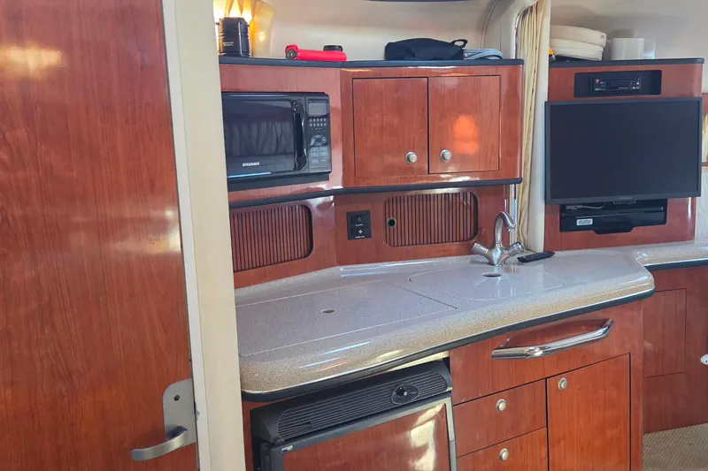 Slide: The Image of 2006 Sea Ray 300 Sundancer interior with kitchenette, microwave, and TV. - 15