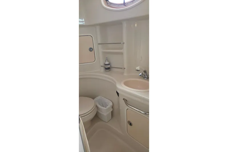 Slide: The Image of 2006 Sea Ray 300 Sundancer bathroom with sink, toilet, and storage compartments. - 16