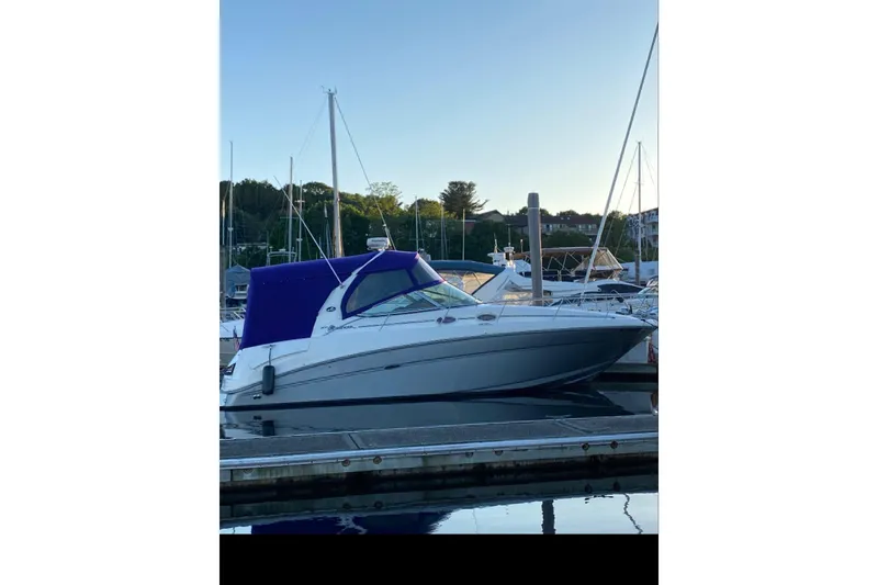 Slide: The Image of 2006 Sea Ray 300 Sundancer docked at marina, featuring blue canopy. - 3