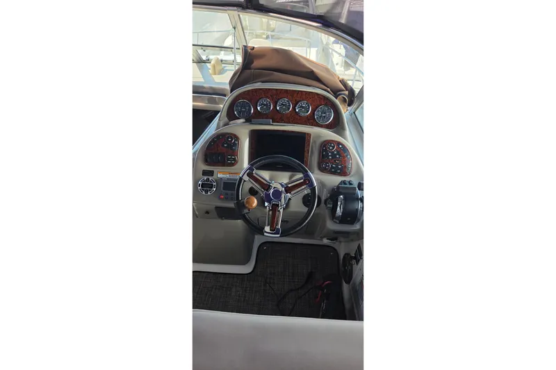 Slide: The Image of Cockpit of 2006 Sea Ray 300 Sundancer with steering wheel and instrument panel. - 6