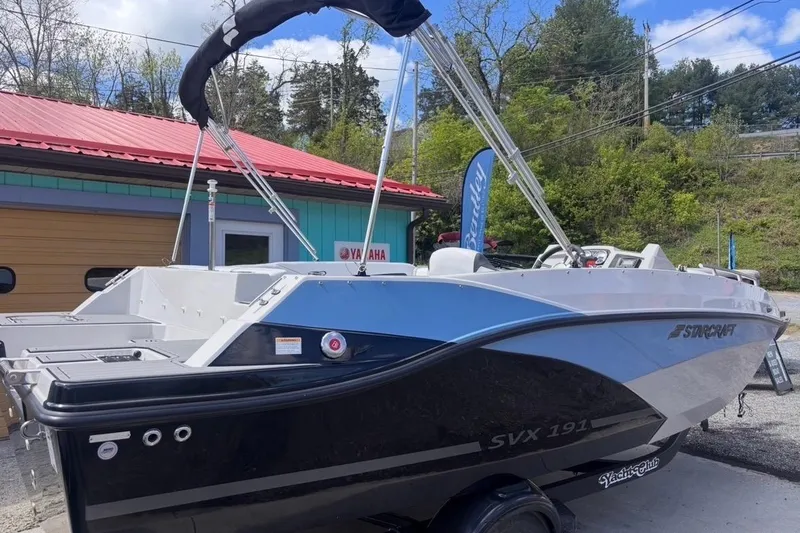 The Image of 2026 Starcraft SVX 191 OB boat with sleek design, parked outdoors near a Yamaha sign. - 0