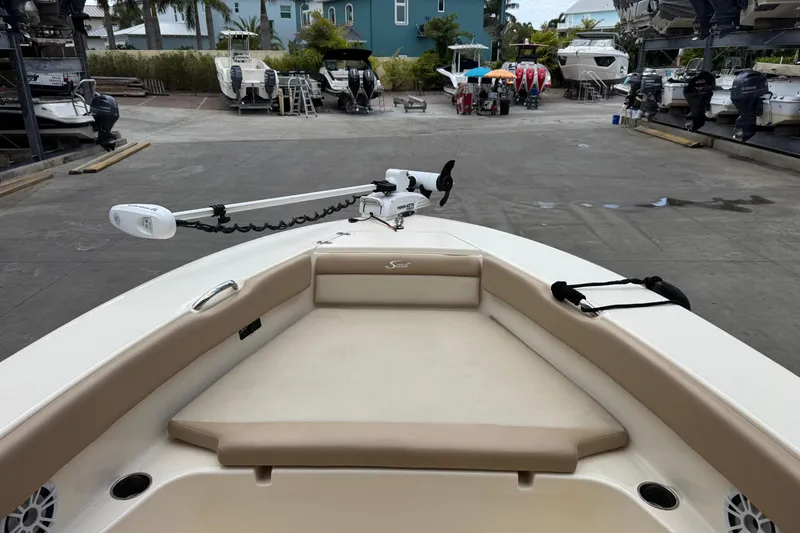 Slide: The Image of 2022 Scout 195 Sport Dorado boat interior at marina, featuring seating and trolling motor. - 4