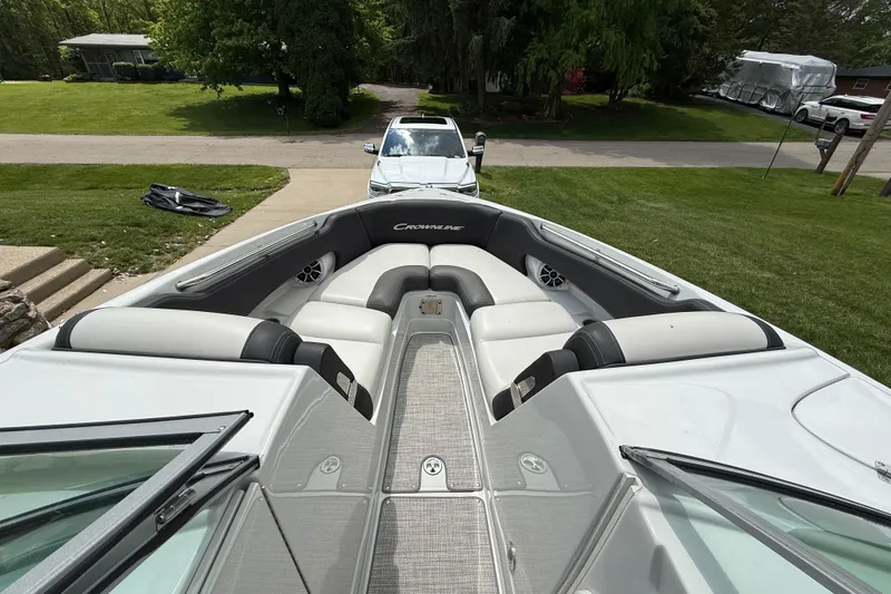 Slide: The Image of 2022 Crownline 280 SS boat with sleek interior, parked on a driveway. - 12
