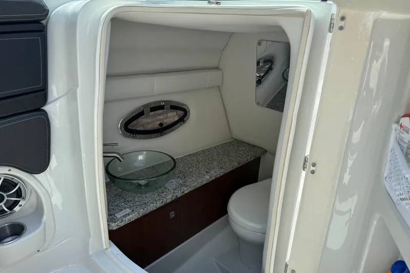 Slide: The Image of 2022 Crownline 280 SS boat interior with modern bathroom, featuring sink and toilet. - 23