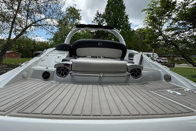 Slide: The Image of 2022 Crownline 280 SS boat with spacious deck and sleek design, surrounded by trees. - 7