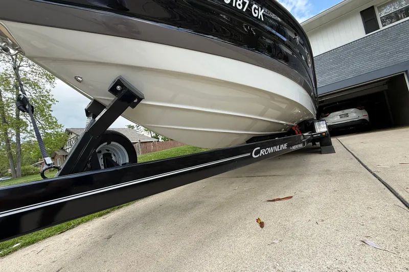 Slide: The Image of 2022 Crownline 280 SS boat on trailer in driveway, showcasing sleek design. - 9