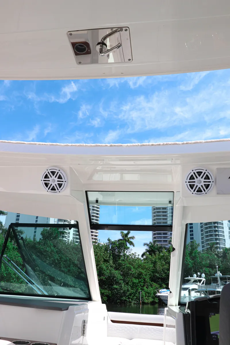 Slide: The Image of 2021 Tiara Sport 34 LX boat interior with speakers, blue sky, and waterfront view. - 10
