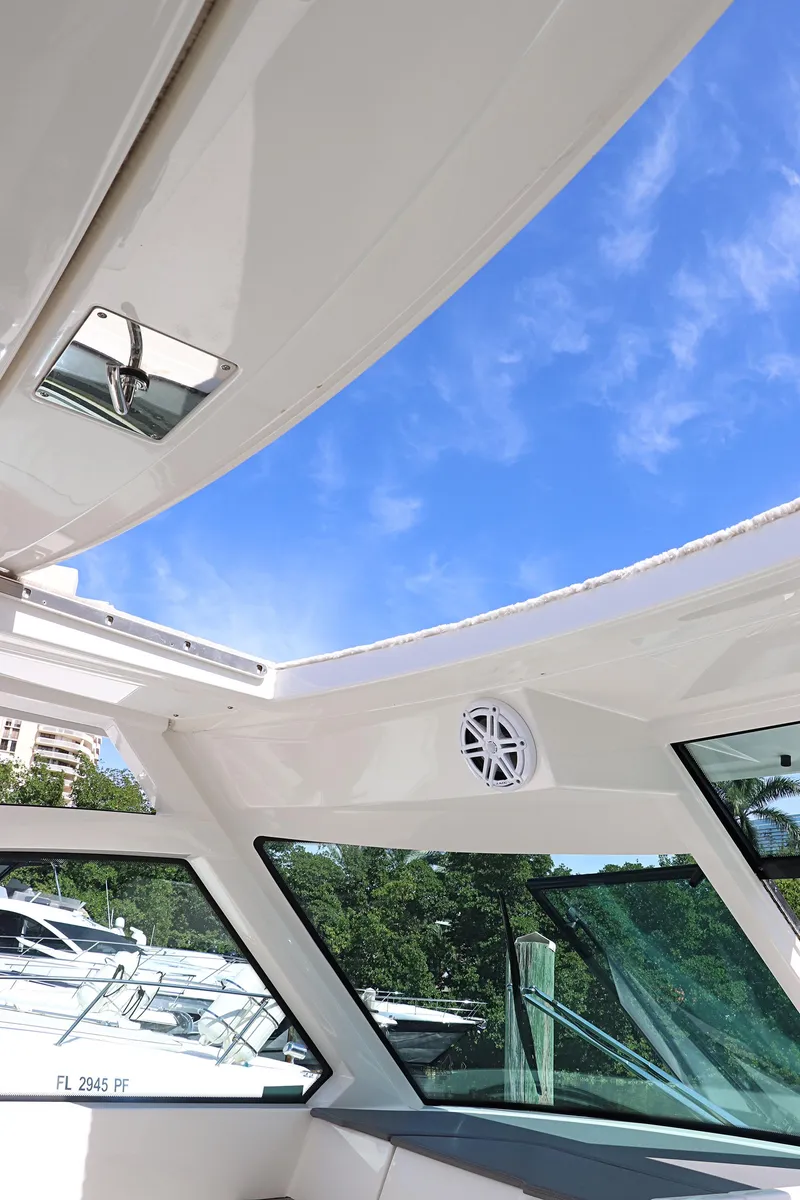Slide: The Image of 2021 Tiara Sport 34 LX boat interior with open roof and clear blue sky. - 11