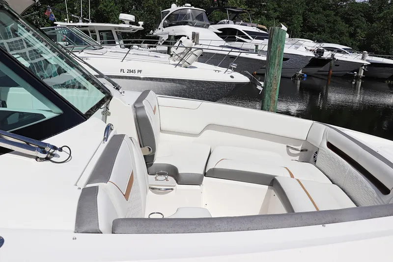 Slide: The Image of 2021 Tiara Sport 34 LX boat interior with seating, docked among other boats. - 12