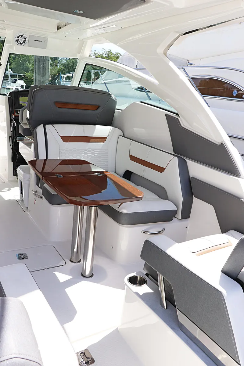 Slide: The Image of 2021 Tiara Sport 34 LX interior with sleek seating and elegant wooden table. - 13