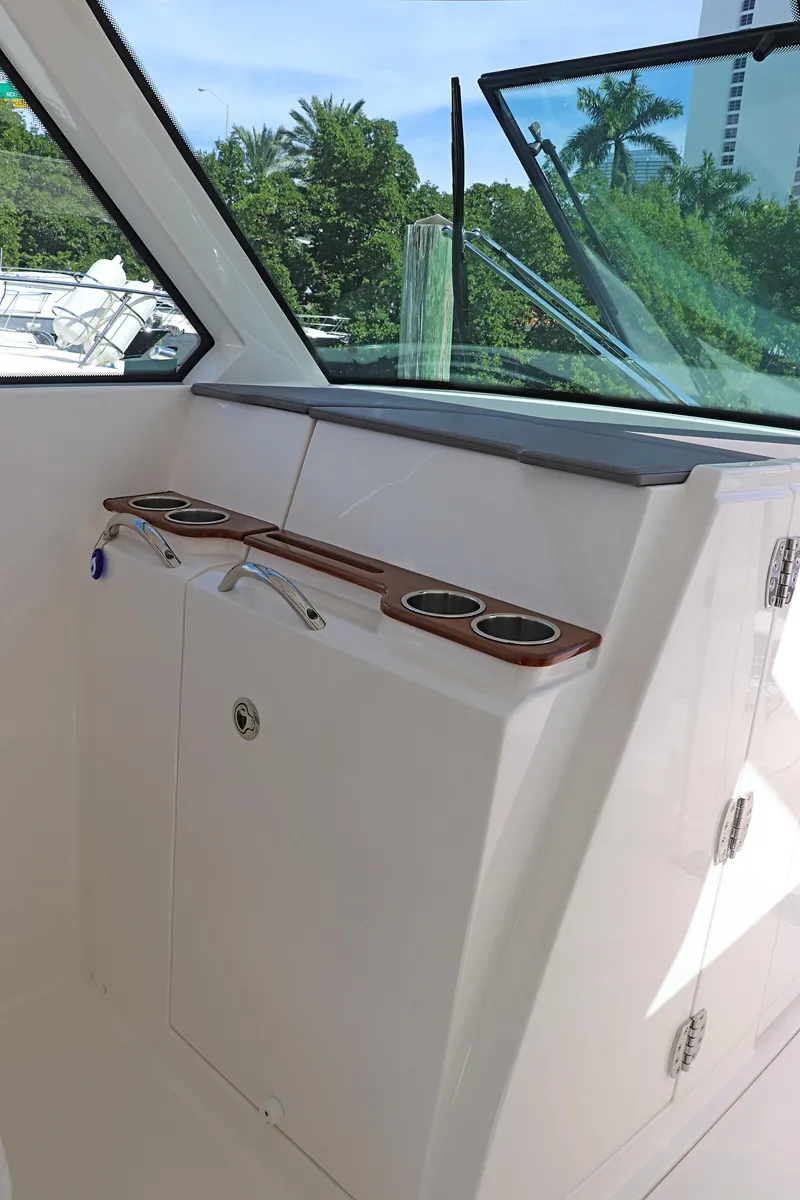 Slide: The Image of 2021 Tiara Sport 34 LX boat interior with cup holders and window view. - 15