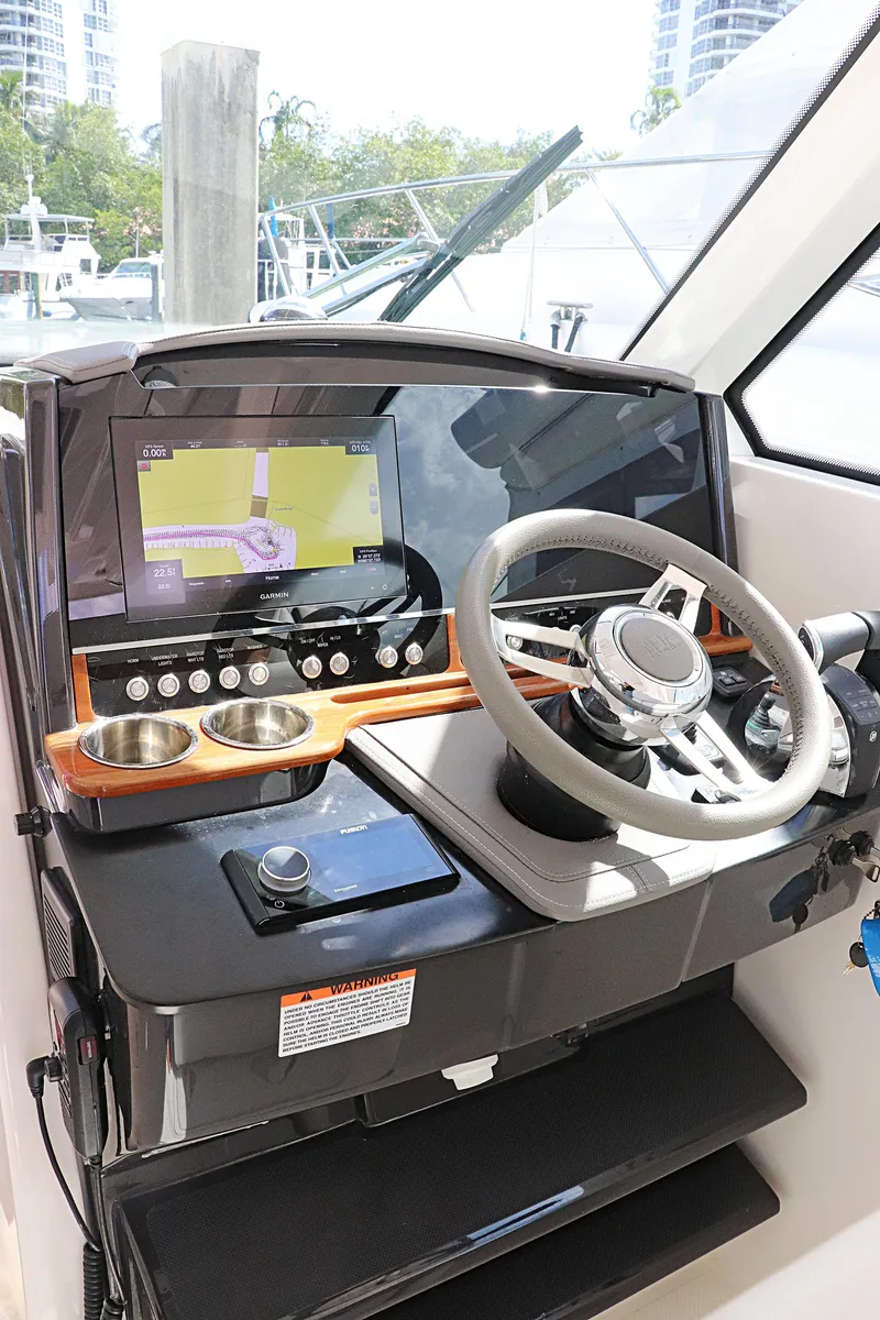 Slide: The Image of 2021 Tiara Sport 34 LX helm with steering wheel and navigation display. - 17