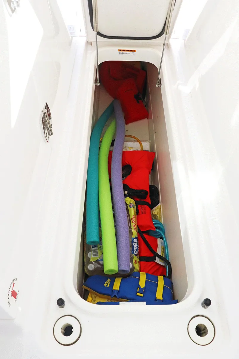 Slide: The Image of Storage compartment in 2021 Tiara Sport 34 LX boat with pool noodles and life jackets. - 24