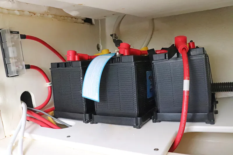 Slide: The Image of Battery compartment of 2021 Tiara Sport 34 LX with red and black cables. - 26