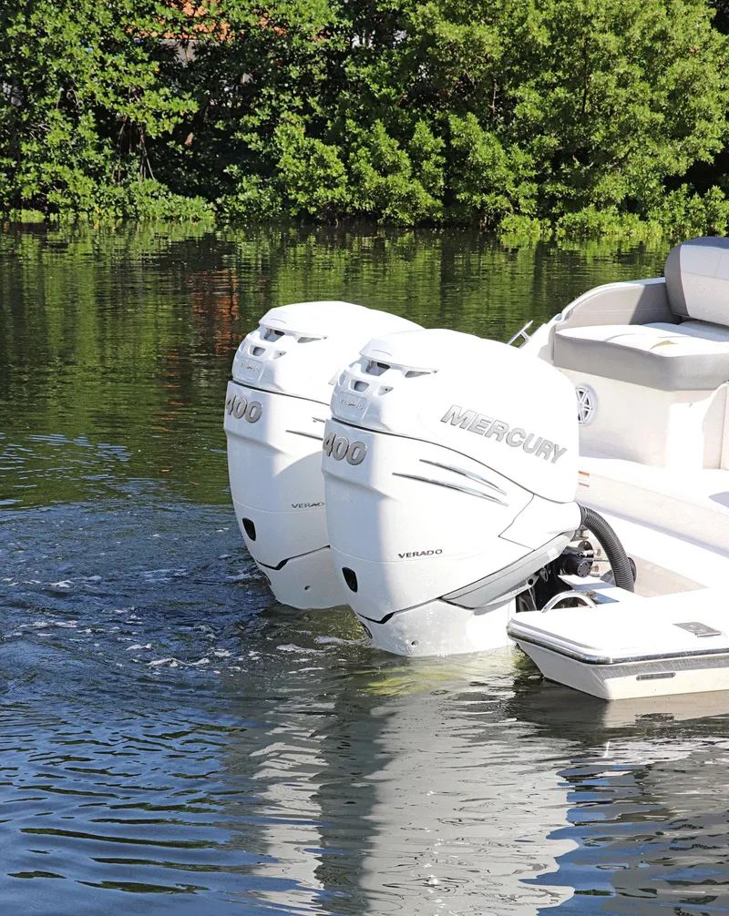 Slide: The Image of 2021 Tiara Sport 34 LX with dual Mercury outboard engines on a calm waterway. - 5