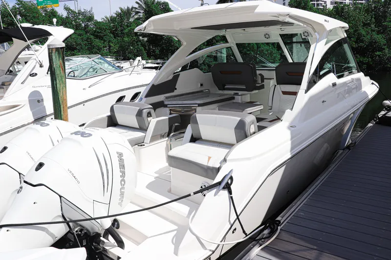 Slide: The Image of 2021 Tiara Sport 34 LX boat docked, featuring sleek design and spacious seating. - 7