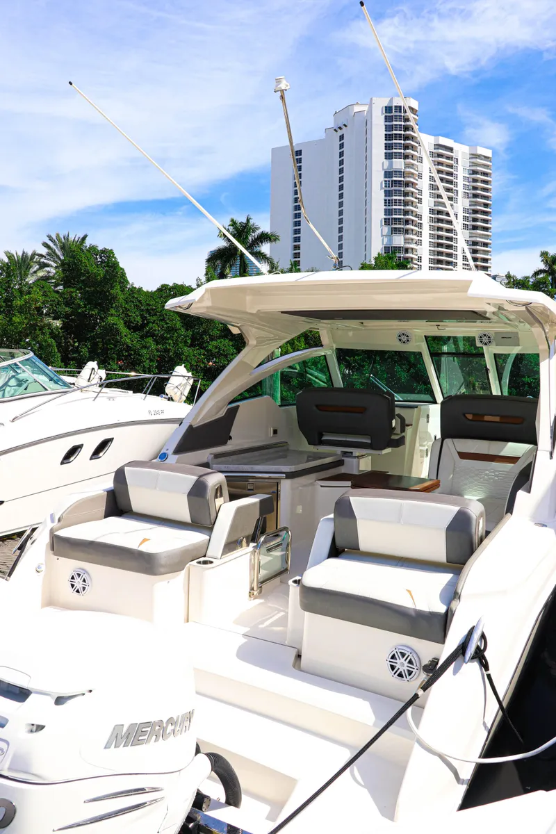 Slide: The Image of 2021 Tiara Sport 34 LX boat docked, featuring spacious seating and modern design. - 8