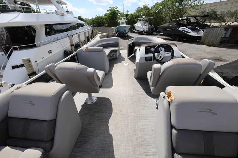 Slide: The Image of 2020 Bennington SX 22 SSRX pontoon boat interior with plush seating and steering console. - 19