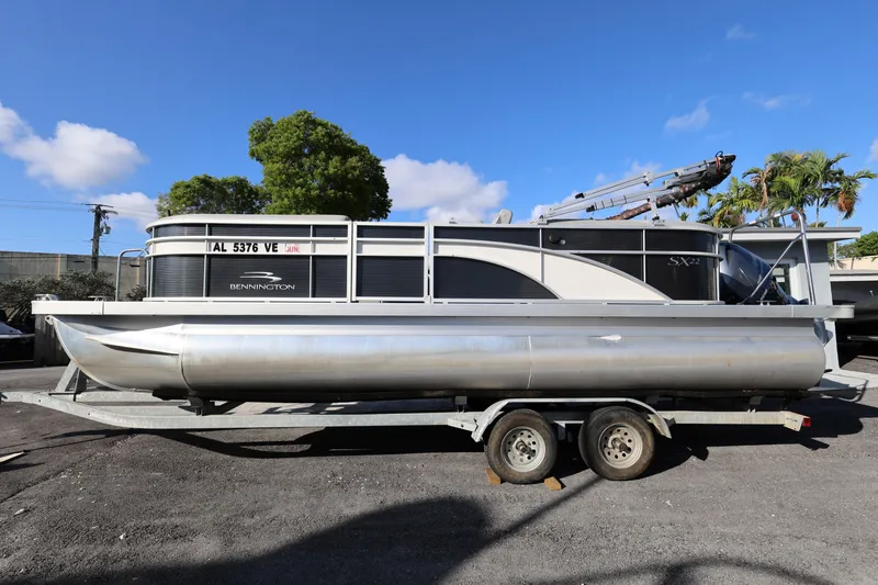 Slide: The Image of 2020 Bennington SX 22 SSRX pontoon boat on trailer under clear blue sky. - 3