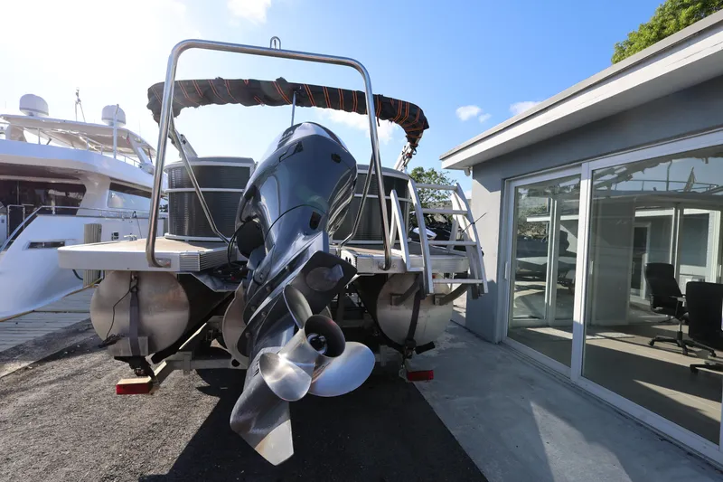 Slide: The Image of 2020 Bennington SX 22 SSRX pontoon boat with outboard motor, docked near modern building. - 6