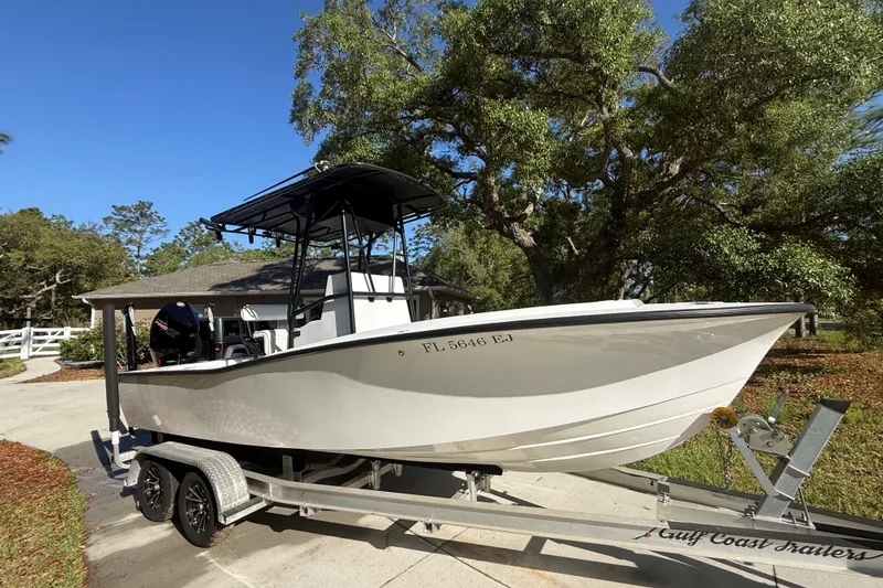 Slide: The Image of 1984 Chris-Craft 213 Scorpion boat on trailer, parked outdoors under trees. - 14