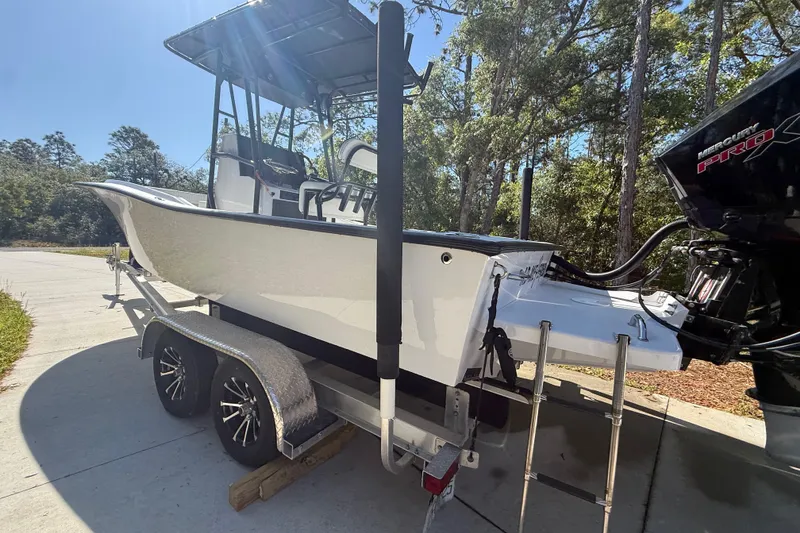 Slide: The Image of 1984 Chris-Craft 213 Scorpion boat on trailer, parked outdoors with trees in background. - 16