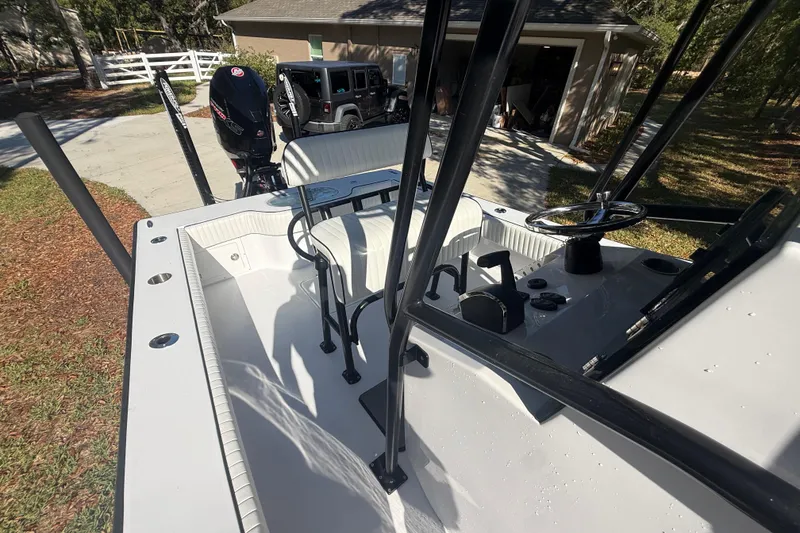 Slide: The Image of 1984 Chris-Craft 213 Scorpion boat interior with steering wheel and controls, parked near a garage. - 57
