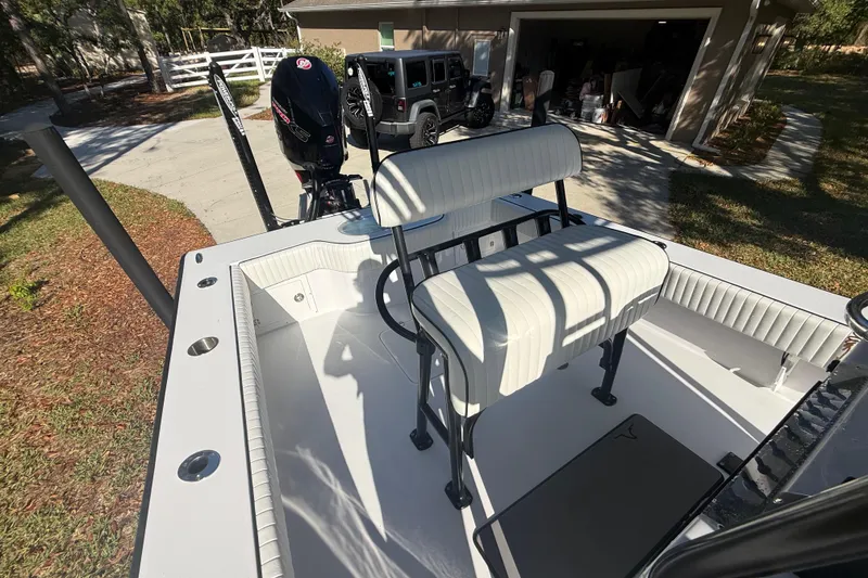 Slide: The Image of 1984 Chris-Craft 213 Scorpion boat with white seating and outboard motor in driveway. - 58