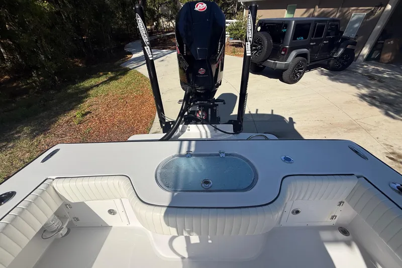 Slide: The Image of 1984 Chris-Craft 213 Scorpion boat with outboard motor, parked near a Jeep. - 66