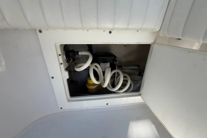 Slide: The Image of 1984 Chris-Craft 213 Scorpion boat compartment with coiled hoses and equipment. - 73