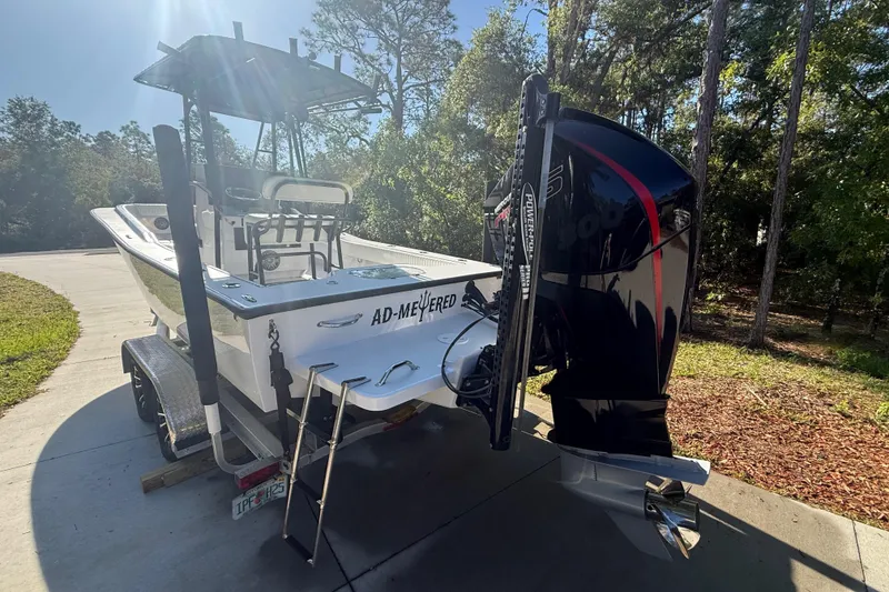 Slide: The Image of 1984 Chris-Craft 213 Scorpion boat on trailer, parked outdoors with trees in background. - 9