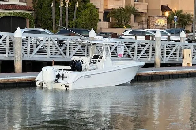 The Image of 2019 Edgewater 245CC boat docked by a waterfront restaurant. - 0