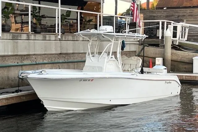 The Image of 2019 Edgewater 245CC boat docked by a waterfront restaurant. - 1