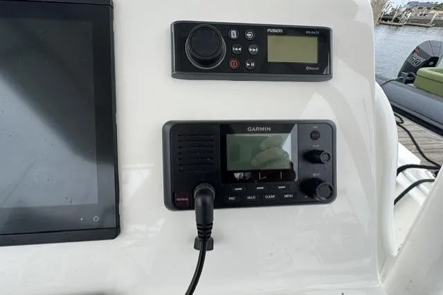 Slide: The Image of Control panel of a 2019 Edgewater 245CC boat with Garmin and Fusion devices. - 10