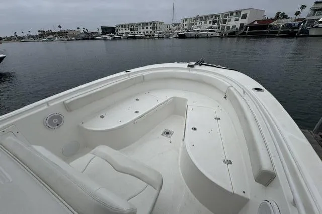 Slide: The Image of 2019 Edgewater 245CC boat interior with seating, docked in a marina. - 13