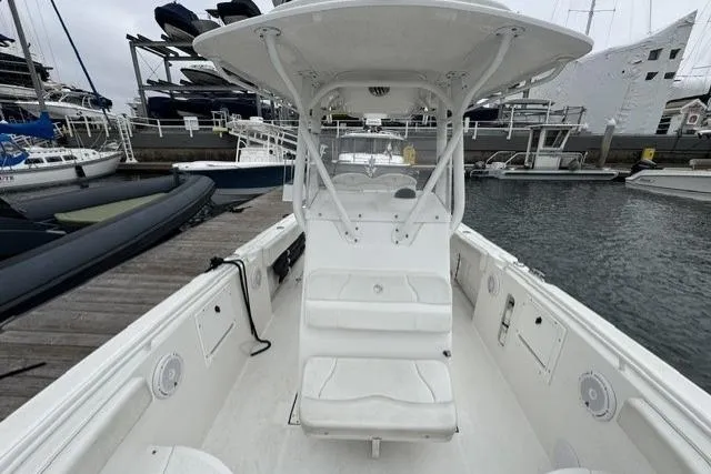 Slide: The Image of 2019 Edgewater 245CC boat docked, featuring spacious seating and modern design. - 15