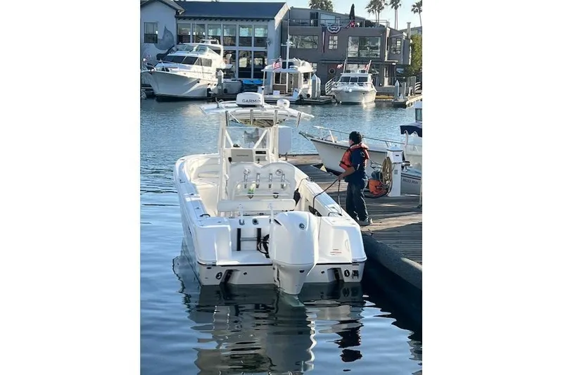 Slide: The Image of 2019 Edgewater 245CC boat docked at marina with person in life jacket nearby. - 3