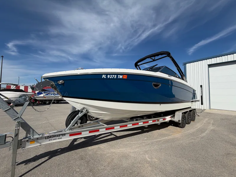 Slide: The Image of 2023 Cobalt R8 Outboard on trailer, blue hull, sunny sky. - 5