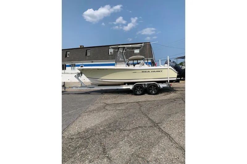 The Image of 2006 Sea Hunt Triton 220 boat on trailer, parked outdoors under a clear sky. - 0