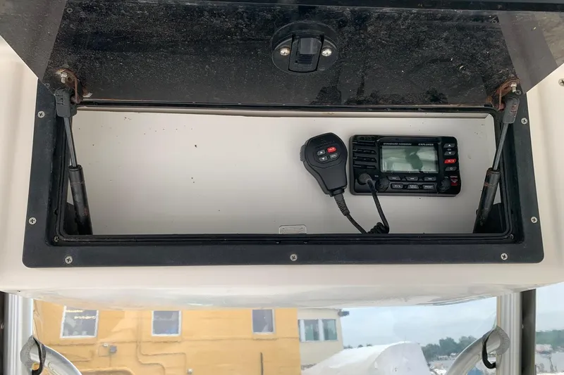 Slide: The Image of Open storage compartment with radio equipment on a 2006 Sea Hunt Triton 220 boat. - 15